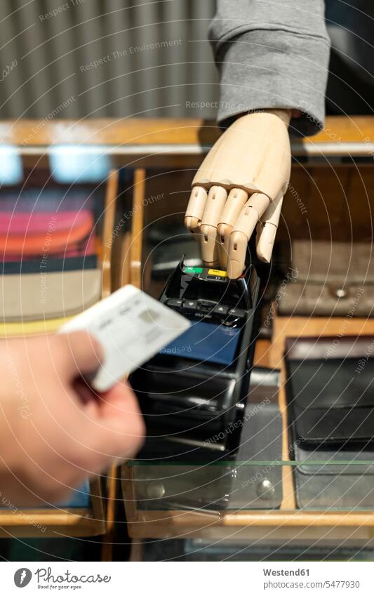 Kunde zahlt mit Kreditkarte, Roboter assistiert Kundin einkaufen Einkaufen shoppen shopping Smartphone iPhone Smartphones bezahlen Kunden Kundschaft Mensch