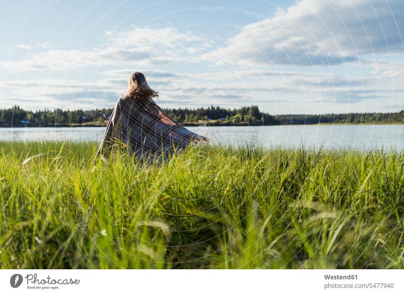 Finnland, Lappland, Frau in eine Decke gewickelt am Seeufer weiblich Frauen Decken eingewickelt einwickeln verpackt eingepackt Seen Erwachsener erwachsen Mensch