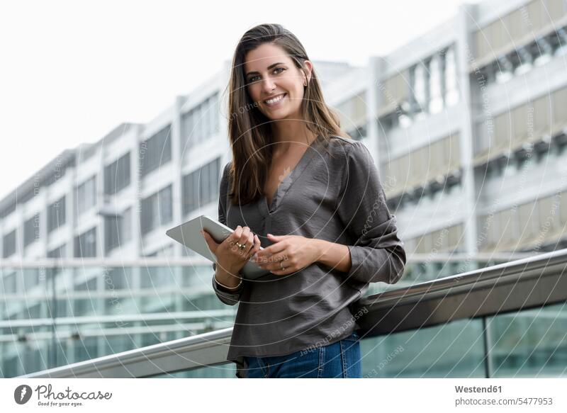 Porträt einer lächelnden jungen Geschäftsfrau mit digitalem Tablet Geschäftsfrauen Businesswomen Businessfrauen Businesswoman Tablet Computer Tablet-PC