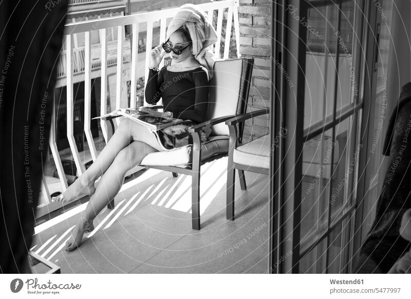 Glamour-Dame beim Lesen einer Zeitschrift auf dem Balkon, Hand auf der Brille Handtuecher Handtücher Magazin Magazine Zeitschriften Kleider Stuehle Stühle