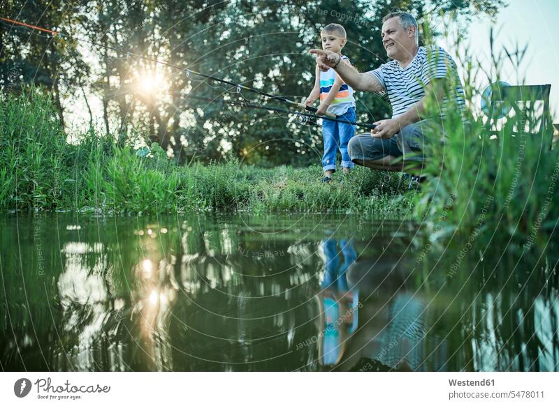 Großvater und Enkel fischen gemeinsam am Seeufer Gemeinsam Zusammen Miteinander Opa Großpapa Großpapas Opas Opi Großväter Opis Enkelsöhne Enkelsohn angeln