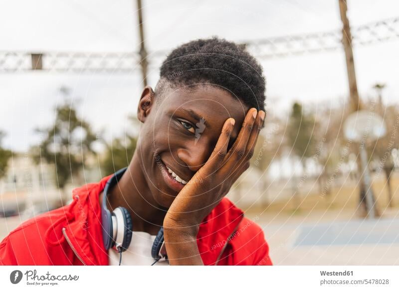 Porträt eines jungen schwarzen Mannes, lachend mit Hand im Gesicht Schwarzer Afrikanisch Farbige Afrikanische Abstammung dunkelhäutig Farbiger junger Mann