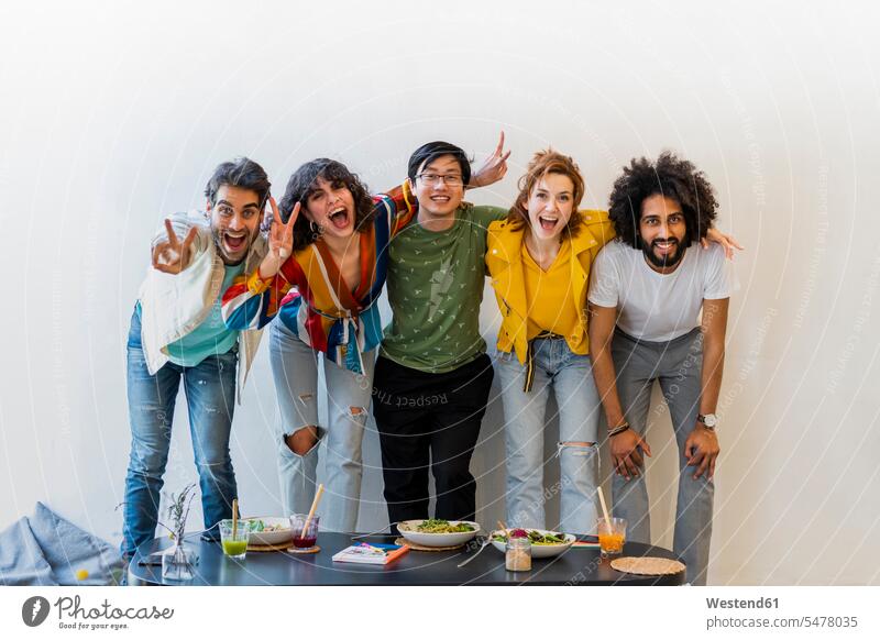 Porträt einer glücklichen Gruppe von Freunden in einem Restaurant Gläser Trinkglas Trinkgläser Tische Arm umlegen Umarmung Umarmungen begeistert Enthusiasmus