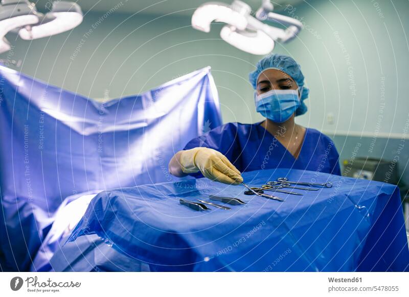 Krankenschwester bringt sterilisierte chirurgische Instrumente in den Operationssaal Leute Menschen People Person Personen Europäisch Kaukasier kaukasisch 1 Ein
