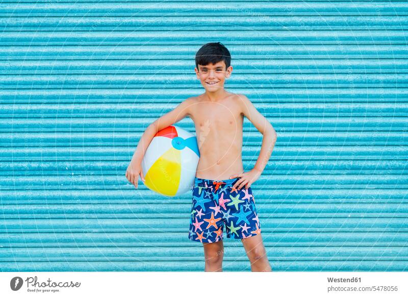 Porträt eines lächelnden Jungen mit Strandball Seesterne Jahreszeiten sommerlich Sommerzeit entspannen relaxen entspanntheit relaxt freuen Frohsinn Fröhlichkeit