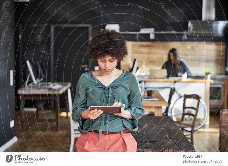 Junge Frau benutzt Tablett im modernen Büro Office Büros Tablet Computer Tablet-PC Tablet PC iPad Tablet-Computer weiblich Frauen Arbeitsplatz Arbeitsstätte