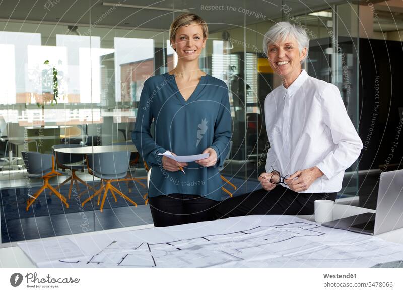 Porträt von zwei selbstbewussten Geschäftsfrauen mit Bauplan im Amt Generation Arbeitskollege Arbeitskollegen Kollege Job Berufe Berufstätigkeit Beschäftigung