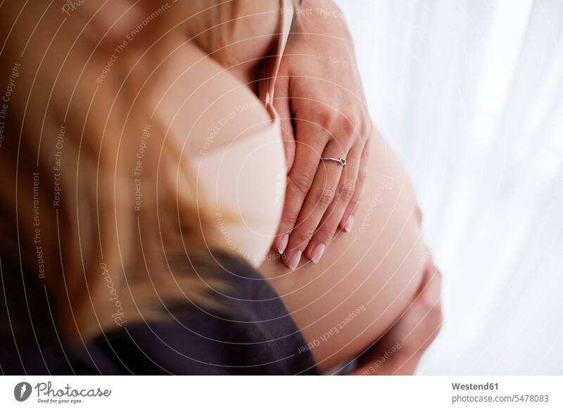 Hochwinkelansicht einer schwangeren Frau Babybauch halten streicheln Schwangere schwangere Frau weiblich Frauen Bauch Bäuche lächeln Hand Hände Kinderzimmer