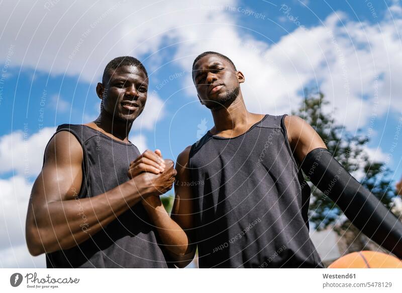 Basketballspieler beim Händeschütteln auf dem Basketballfeld Leute Menschen People Person Personen Afrikanisch Afrikanische Abstammung dunkelhäutig Farbige