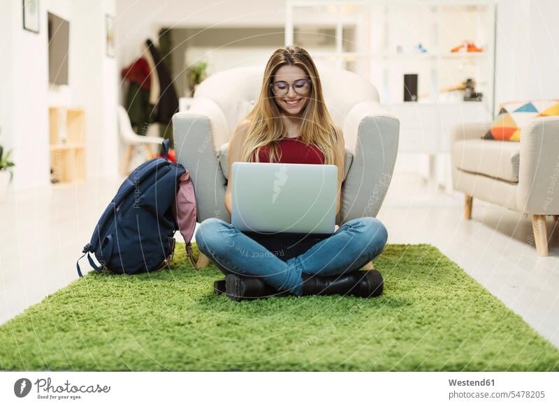 Lässige junge Frau benutzt Laptop im Coworking Space Büro Office Büros lächeln Notebook Laptops Notebooks weiblich Frauen Arbeitsplatz Arbeitsstätte