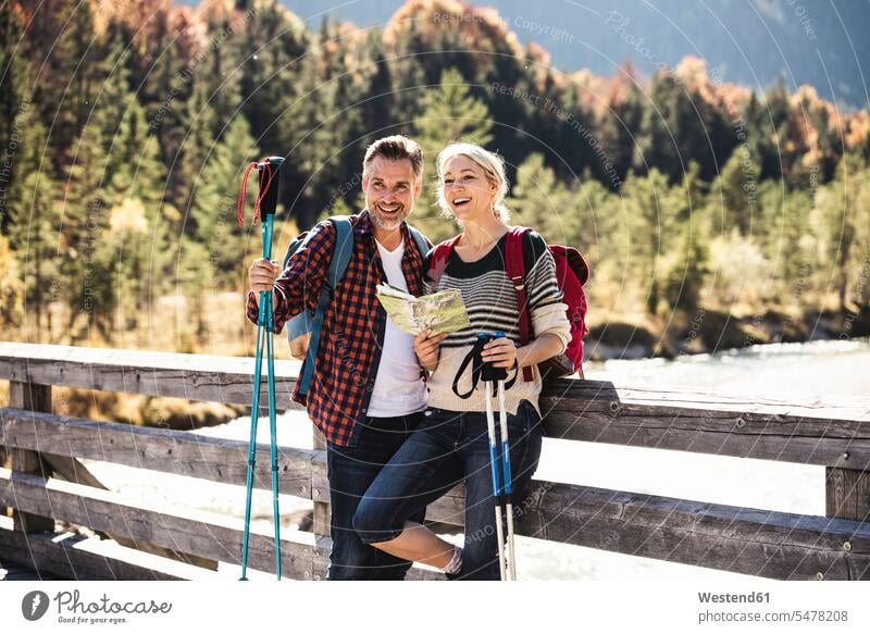 Österreich, Alpen, glückliches Paar auf einer Wanderung mit Karte auf einer Brücke Europäer Europäisch Kaukasier kaukasisch reifer Mann reife Männer 45-50 Jahre