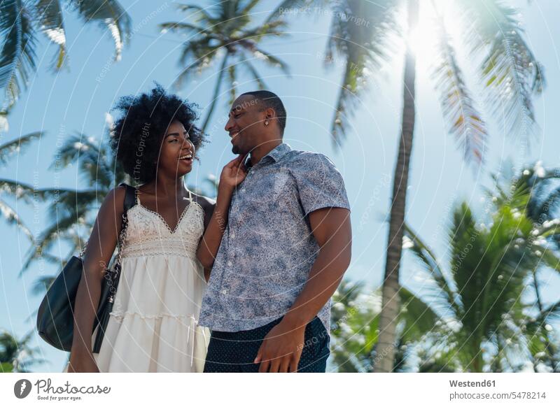 USA, Florida, Miami Beach, glückliches junges Paar an Palmen im Sommer Pärchen Paare Partnerschaft Sommerzeit sommerlich Glück glücklich sein glücklichsein