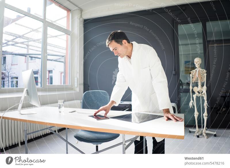 Arzt in der Arztpraxis mit Skelett im Hintergrund Doktoren Ärzte Arztpraxen Praxis Medizin medizinisch Gesundheitswesen Deutschland Kompetenz kompetent
