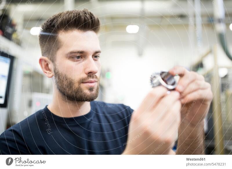 Mann untersucht Werkstück in einer Fabrik Job Berufe Berufstätigkeit Beschäftigung Jobs Arbeiter Techniken Technologie Anlagenbau Ingenieurwissenschaft