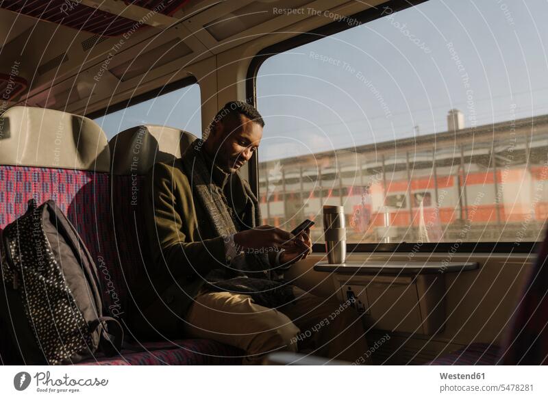 Stilvoller Mann benutzt Smartphone im Zug geschäftlich Geschäftsleben Geschäftswelt Geschäftsperson Geschäftspersonen Businessmann Businessmänner