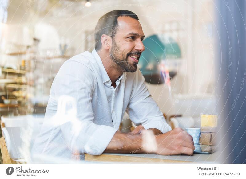 Lächelnder Mann mit Tablette in einem Cafe Tablet Computer Tablet-PC Tablet PC iPad Tablet-Computer Männer männlich Kaffeehaus Bistro Cafes Café Cafés