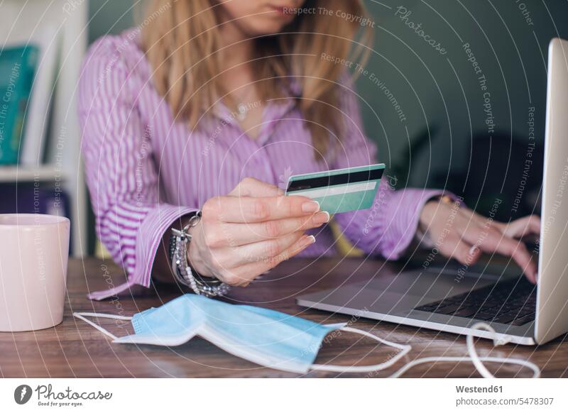 Geschäftsfrau mit Kreditkarte macht Online-Zahlung über Laptop im Büro Farbaufnahme Farbe Farbfoto Farbphoto Innenaufnahme Innenaufnahmen innen drinnen