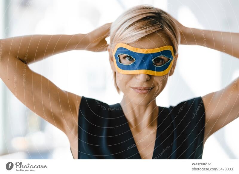 Porträt einer blonden Geschäftsfrau, die eine Superwoman-Maske trägt Leute Menschen People Person Personen Europäisch Kaukasier kaukasisch 1 Ein ein Mensch