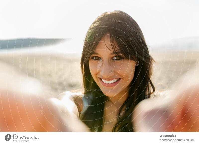 Porträt einer lächelnden jungen Frau am Strand Koepfe Köpfe Gesichter entspannen relaxen sommerlich Sommerzeit entspanntheit relaxt freuen Frohsinn Fröhlichkeit