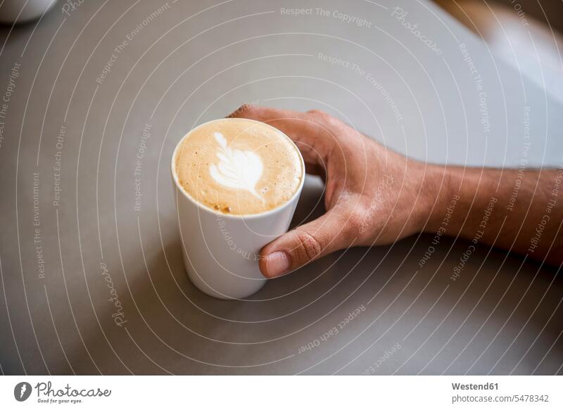 Hand und Tasse Cappuccino in einem Cafe Kaffeehaus Bistro Cafes Café Cafés Kaffeehäuser Cappucino Milchschaum Hände Tassen Gastronomie Milchkaffee Melange