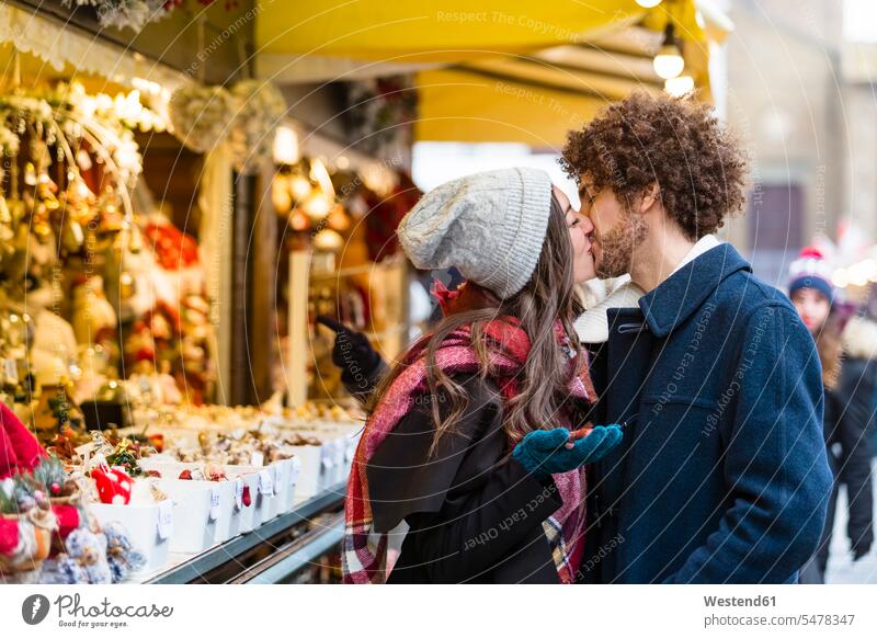 Glückliches zärtliches junges Paar küsst sich auf dem Weihnachtsmarkt Zuneigung Christkindlmarkt glücklich glücklich sein glücklichsein Pärchen Paare