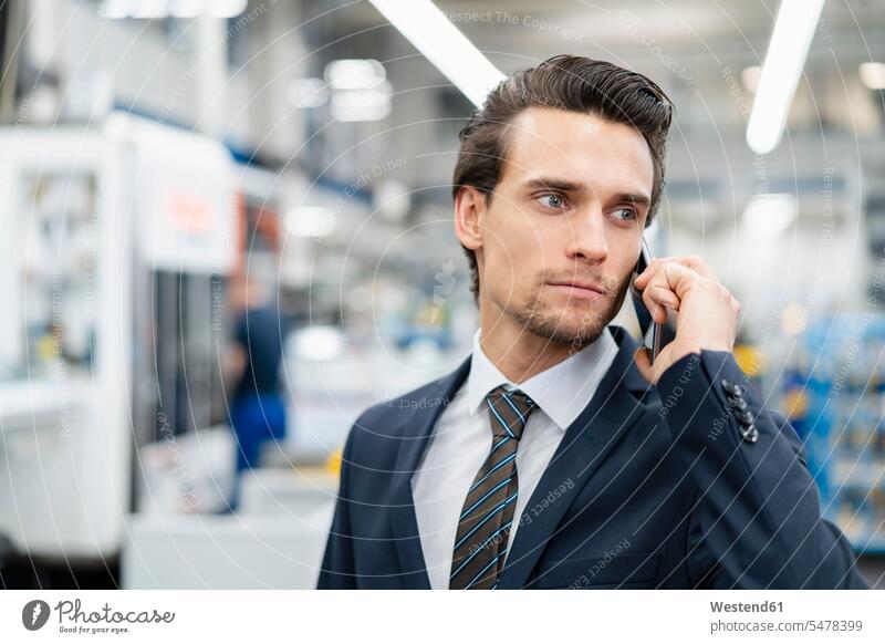 Porträt eines Geschäftsmannes am Handy in einer Fabrik Businessmann Businessmänner Geschäftsmänner telefonieren anrufen Anruf telephonieren Fabriken Portrait