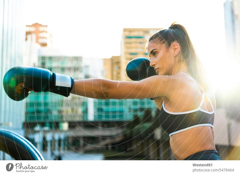 Sportliche junge Frau boxt in der Stadt staedtisch städtisch boxen weiblich Frauen sportlich Außenaufnahme draußen im Freien Erwachsener erwachsen Mensch