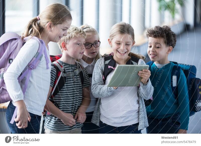 Glückliche Schülerinnen und Schüler betrachten die Tafel auf dem Schulkorridor ansehen glücklich glücklich sein glücklichsein Schule Schulen Tablet