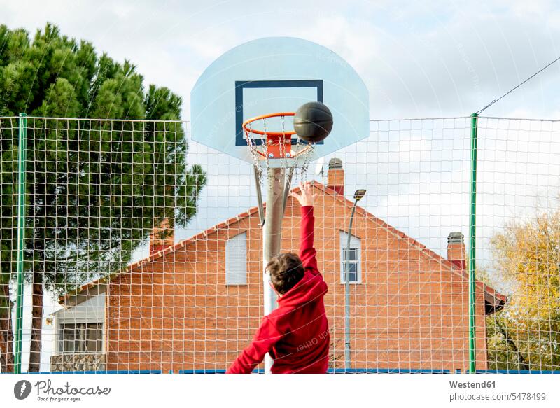 Teenager beim Basketball spielen, Dunking Bälle springen Spruenge Sprünge hüpfen Muße Fit gesund Gesundheit Anreiz Ansporn Antrieb motivieren motiviert Wolken
