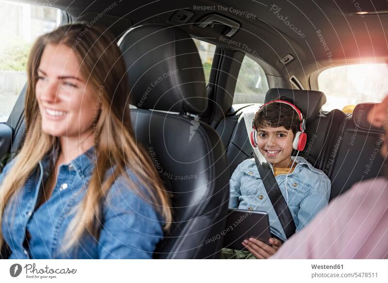 Familie mit einem Jungen auf Autoreise mit Tablette fahren fahrend fahrender fahrendes Wagen PKWs Automobil Autos Tablet Computer Tablet-PC Tablet PC iPad