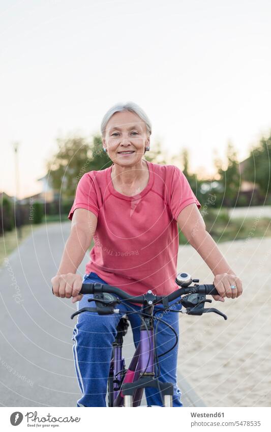 Porträt einer lächelnden älteren Frau, die Fahrrad fährt Seniorin Seniorinnen alt Bikes Fahrräder Räder Rad fahren radfahren fahrradfahren radeln Portrait