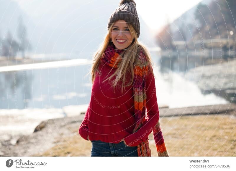 Junge blonde Frau im Winter an einem See Glück glücklich sein glücklichsein geniessen Genuss Leute Menschen People Person Personen Europäisch Kaukasier