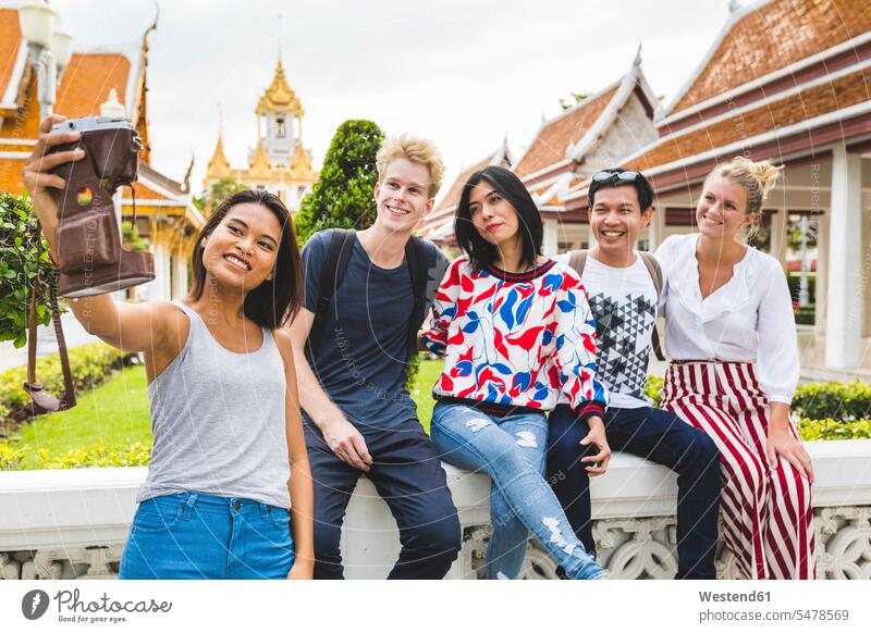 Thailand, Bangkok, fünf Freunde machen ein Selfie mit Smartphone vor einer Tempelanlage Fotoapparat Kamera Fotokamera Foto machen Fotos machen fotografieren