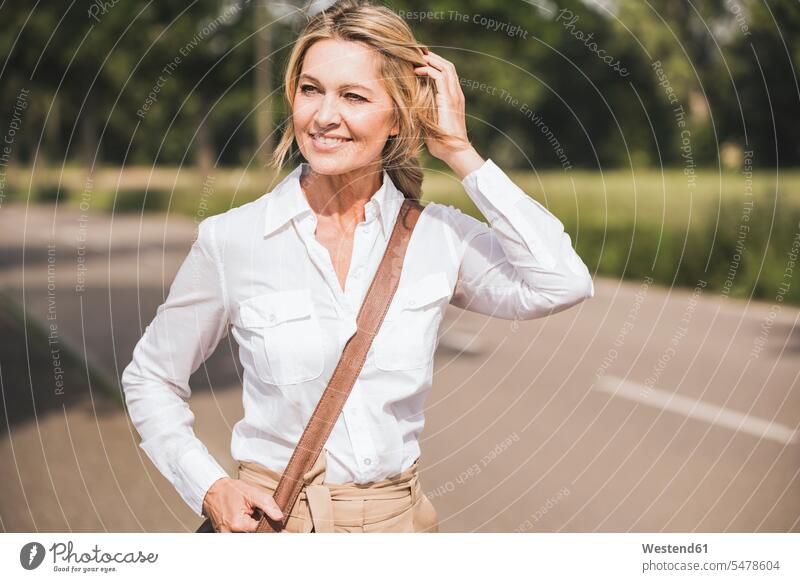 Nachdenkliche Geschäftsfrau trägt Schultertasche auf der Straße Farbaufnahme Farbe Farbfoto Farbphoto Außenaufnahme außen draußen im Freien Tag