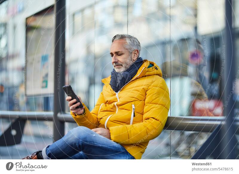 Erwachsener Mann benutzt Handy in der Stadt Leute Menschen People Person Personen Alleinstehende Alleinstehender Singles Unverheiratete Unverheirateter