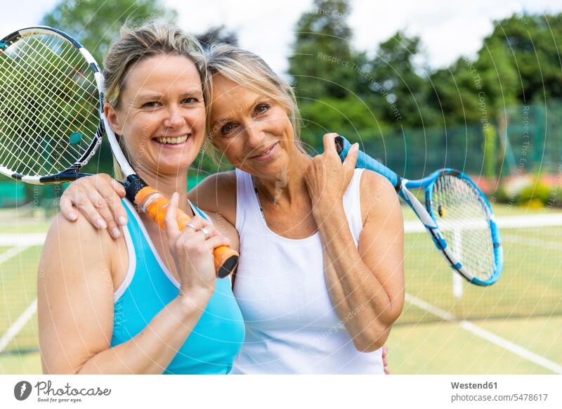 Porträt von zwei glücklichen reifen Frauen auf Rasenplatz im Tennisclub Leute Menschen People Person Personen Europäisch Kaukasier kaukasisch 2 2 Menschen