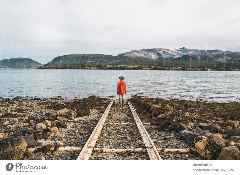 Nordnorwegen, Mann steht allein am Fjord und schaut auf die Aussicht Nord-Noreg Davvi-Norga Nord-Norge Ausblick Ansicht Überblick einsam einsame einsamer