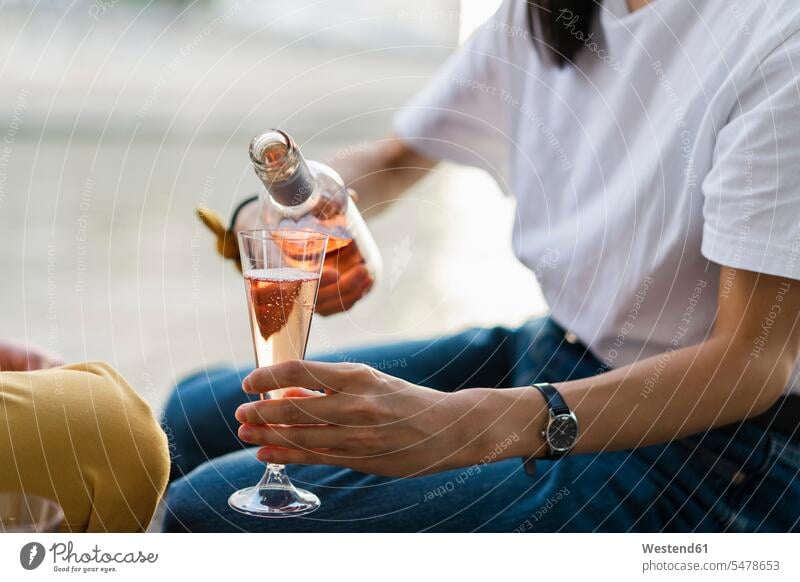 Nahaufnahme einer Frau, die prickelnden Rotwein einschenkt Sekt einschenken eingiessen gießen eingießen Paar Pärchen Paare Partnerschaft Alkohol