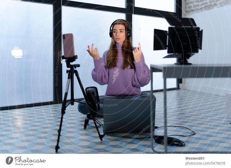 Porträt einer jungen Frau, die mit Laptop und Smartphone in einem Studio Aufnahmen macht Job Berufe Berufstätigkeit Beschäftigung Jobs geschäftlich