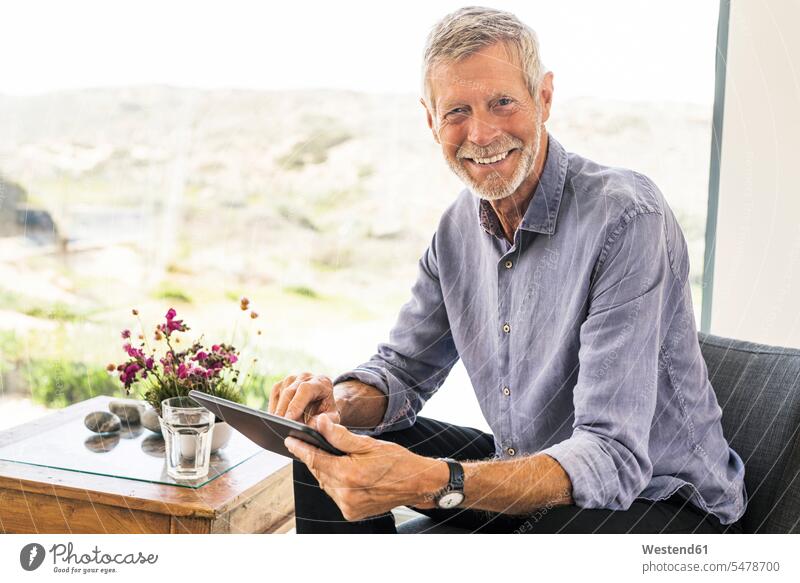 Porträt eines lächelnden älteren Mannes mit Tablette zu Hause selbstbewusst Selbstvertrauen Vertrauen Zuversichtlich zufrieden gefühlvoll Emotionen Empfindung