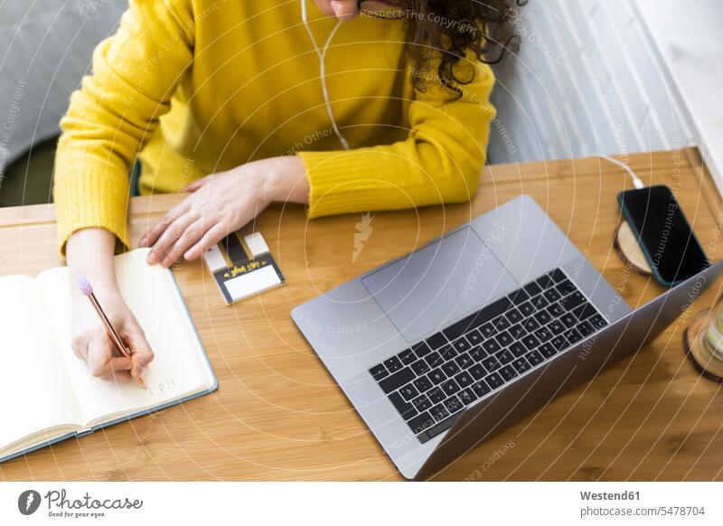 Nahaufnahme einer Frau, die am Schreibtisch im Heimbüro arbeitet und Notizen macht Leute Menschen People Person Personen Europäisch Kaukasier kaukasisch 1 Ein