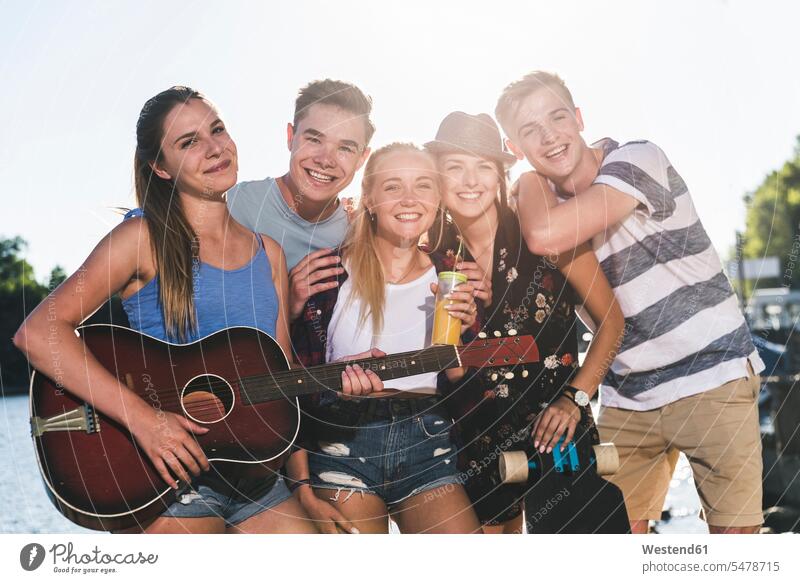 Porträt einer Gruppe glücklicher Freunde mit Gitarre am Flussufer Gruppe von Menschen Menschengruppe Fluesse Fluß Flüsse Glück glücklich sein glücklichsein