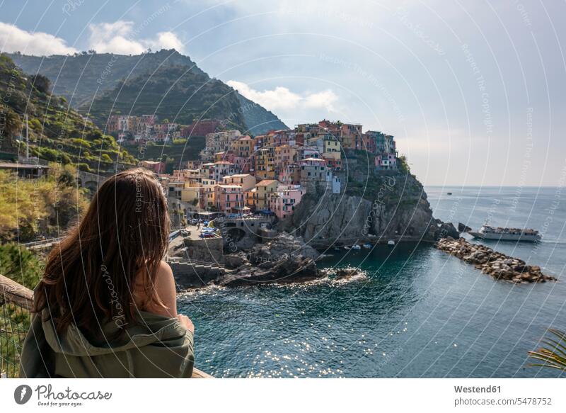 Italien, Ligurien, La Spezia, Nationalpark Cinque Terre, junge Frau mit Blick auf Manarola Reisende Reisender Aussichtspunkt Touristin reisen Travel verreisen