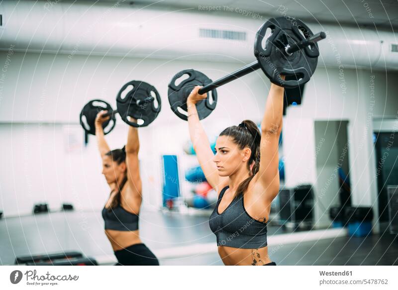Zwillingsschwestern trainieren mit Gewichten in der Turnhalle fit gesund Gesundheit Fitnessgeraet Fitnessgeraete Fitnessgeräte ausüben Übung Muße Leistungen