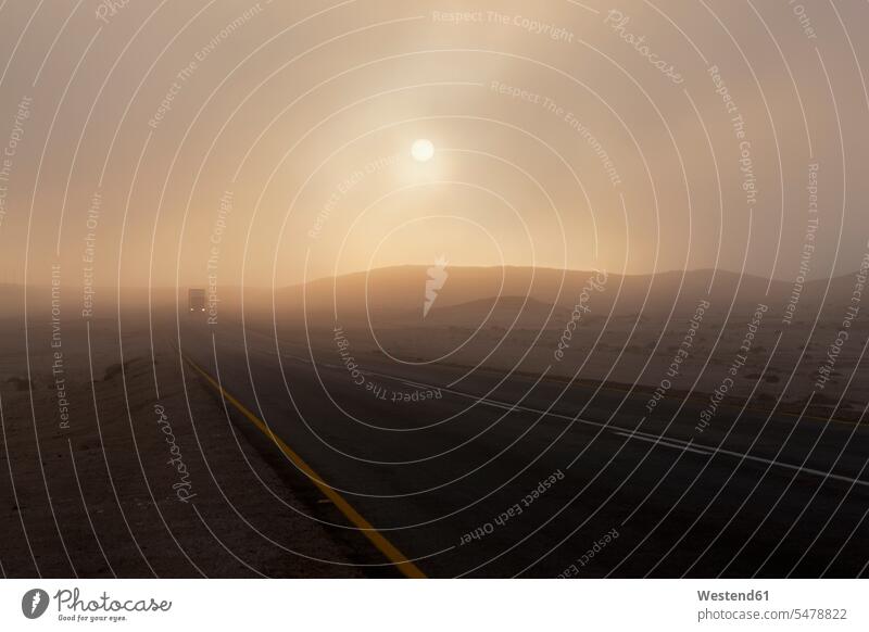 Afrika, Namibia, Namib-Wüste, Swakopmund, Ansicht des Fahrzeugs auf nebliger Straße im Morgengrauen Republik Namibia beleuchtet Beleuchtung Farbaufnahme
