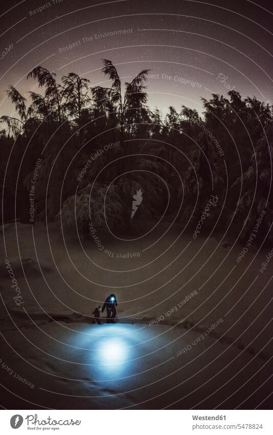 Finnland, Kuopio, Mutter und Tochter zu Fuß mit Schlitten im Winterwald bei Nacht Naturerlebnis Stimmungsvoller Himmel Stirnlampe Kopfleuchte Kopflampe