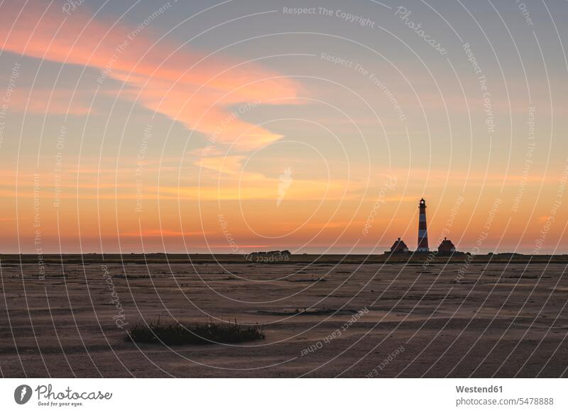 Deutschland, Schleswig-Holstein, Westerhever, Sandstrand im Morgengrauen mit dem Leuchtturm von Westerheversand im Hintergrund Außenaufnahme außen draußen