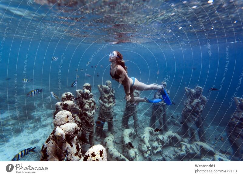 Frau schwimmt in der Nähe einer Unterwasser-Skulptur von Jason deCaires Taylor, Insel Gili Meno, Bali, Indonesien Rundung Rundungen Kreise kreisfoermig