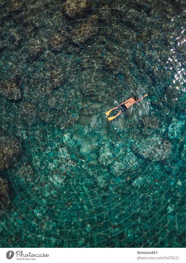 Indonesien, Bali, Mann schwimmt im Meer am Strand von Amed entdecken Unterwasserwelt unter Wasser Unterwasserwelten Menschen zufällige Personen Draufsicht