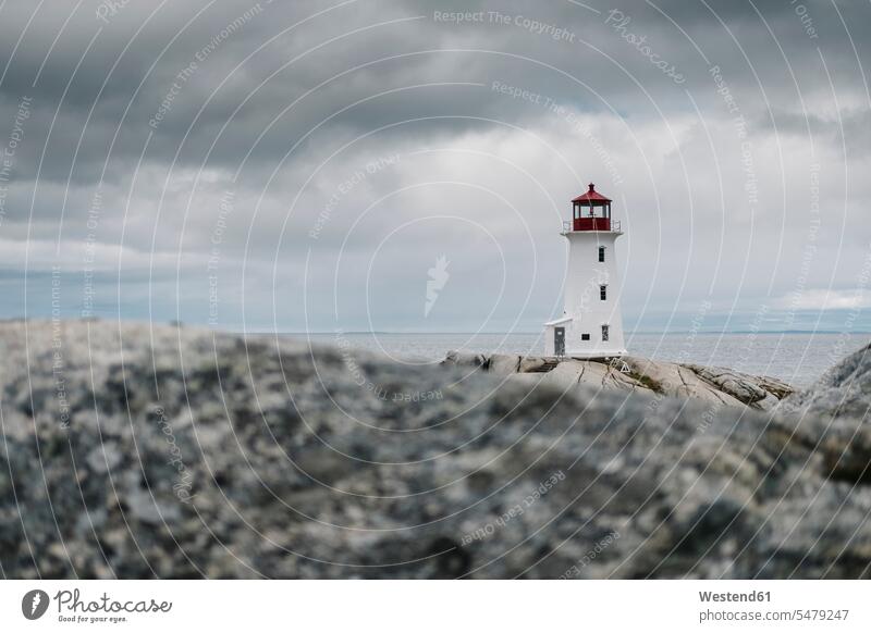 Peggys-Point-Leuchtturm auf einer Felsformation auf dem Meer vor bewölktem Himmel, Neuschottland, Kanada Farbaufnahme Farbe Farbfoto Farbphoto Canada